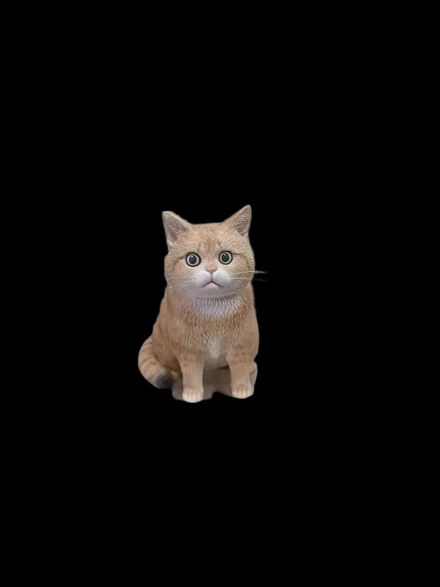 Front view of a hand-painted orange cat figurine displayed on a rotating stand