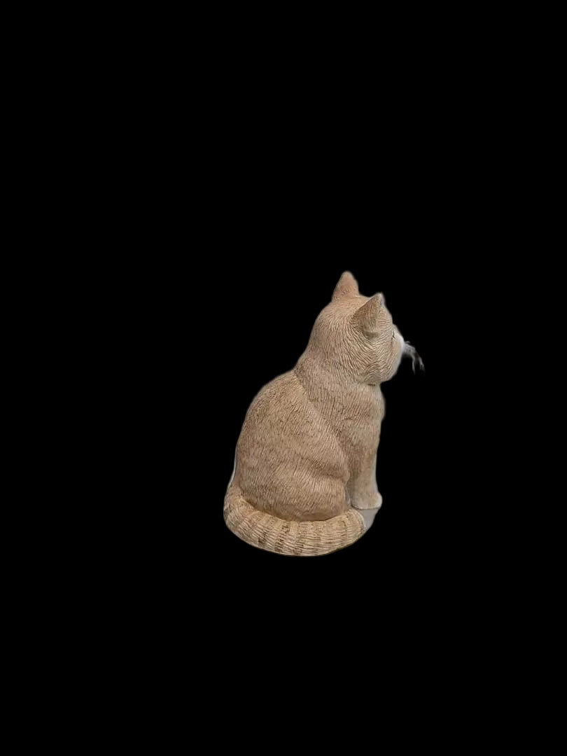 Side view of a custom orange cat figurine showing its sculpted body and tail